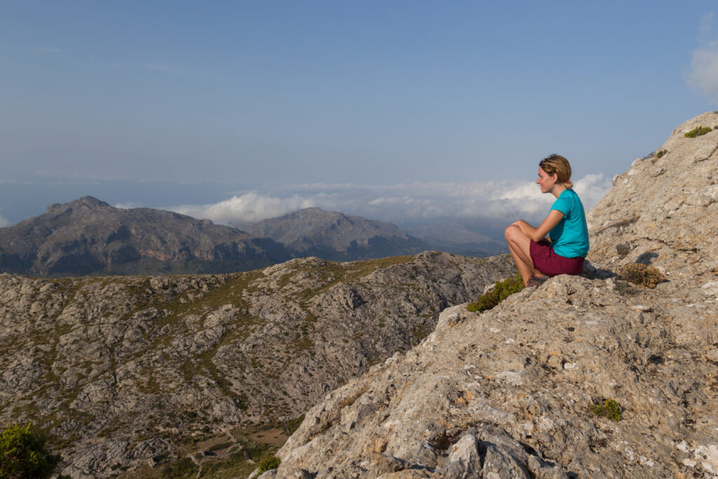 Kobieta siedząca w górach, spoglądająca na widok.