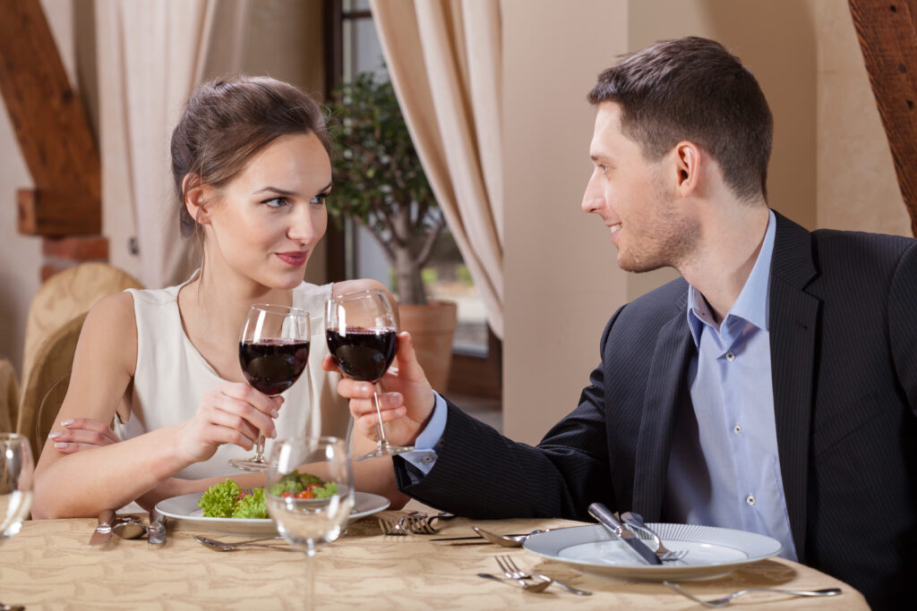 Para wznosząca toast winem w restauracji.