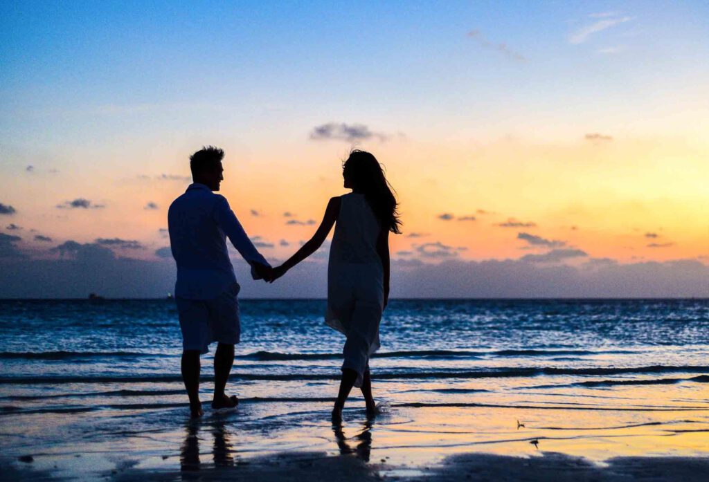 Prezent na ślub cywilny: para spaceruje nad morzemm, zachód słońca