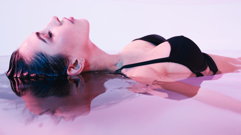 Floating - kobieta w kostiumie kąpielowym dryfuje na wodzie