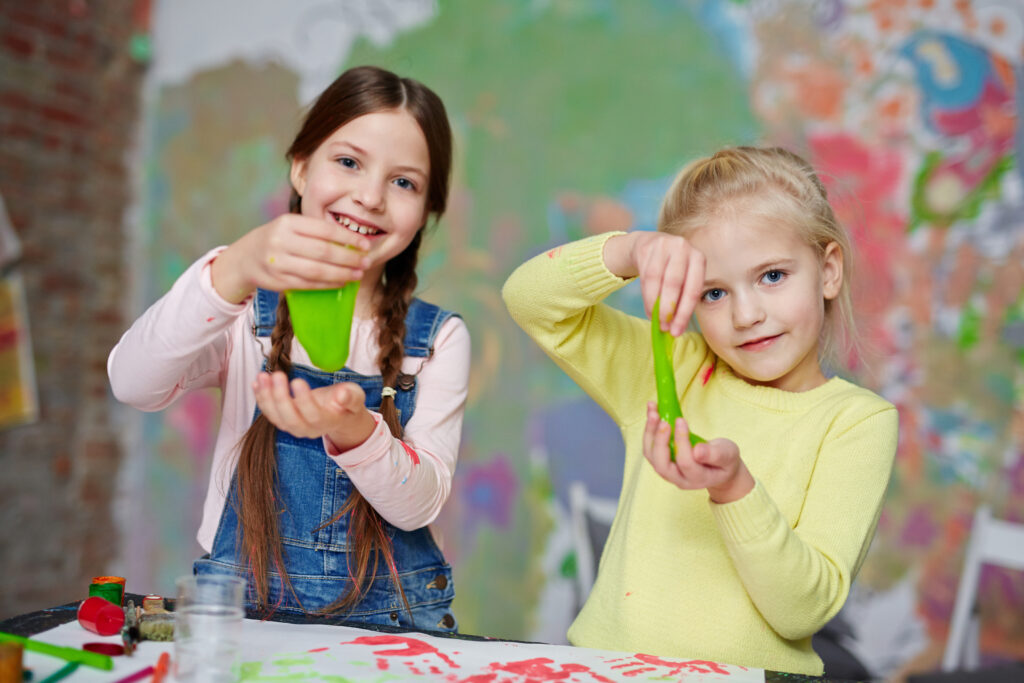 Prezent na Dzień Dziecka dla 10 latka: dwie dziewczynki pokazują prace plastyczne