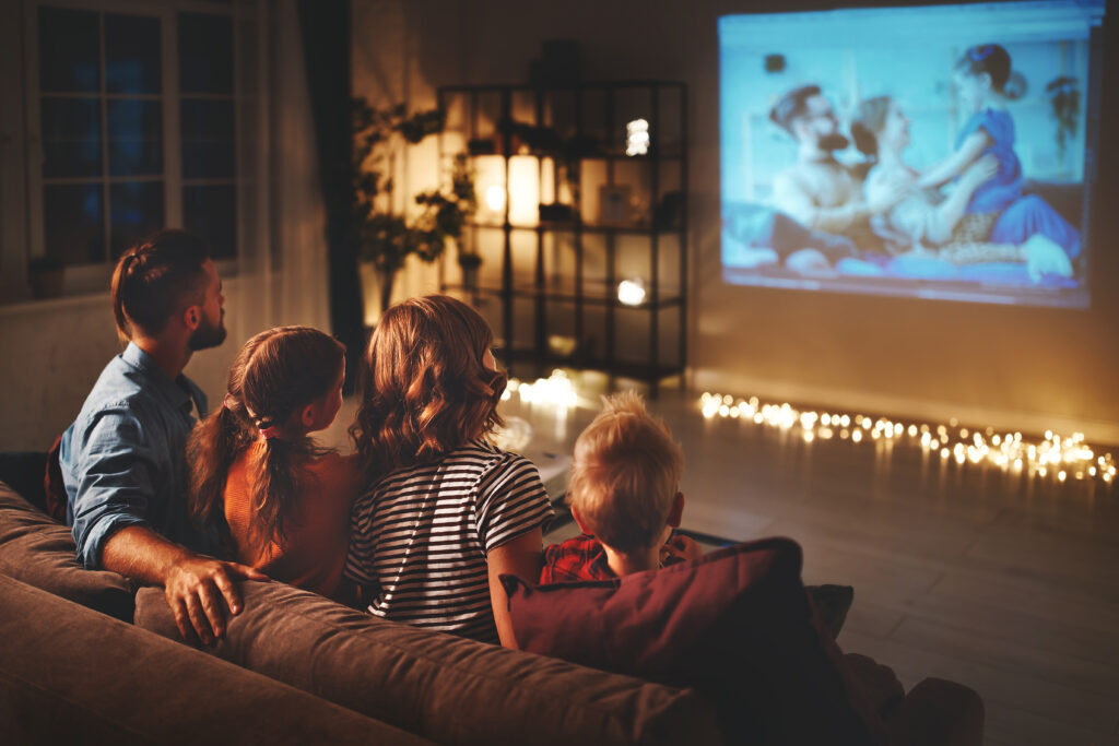 Prezent na Dzień Dziecka dla 11 latka - rodzina ogląda film na projektorze, w domu.
