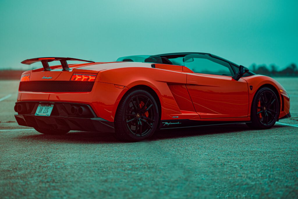 Czerwone Lamborghini Gallardo stoi na betonowej drodze.