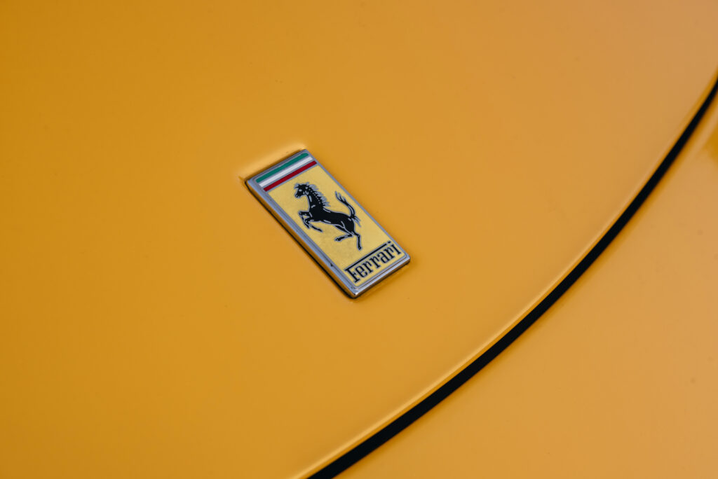 Logo Ferrari na żółtej masce samochodu Ferrari